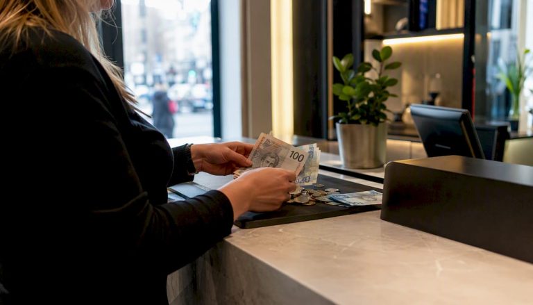 Rankose skaičiuojami Švedijos kronų banknotai ir monetos