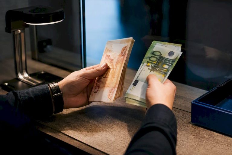 Rankos tikrina rublių ir eurų banknotus