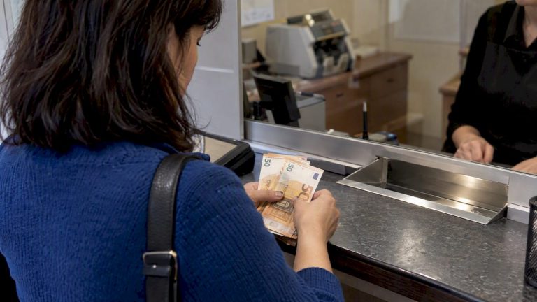 Klientė valiutos keitykloje skaičiuoja gautus užsienio banknotus